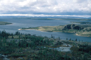 View of the outlet of Ashuapun where it empties into Ashuapun-shipu. Archaeologist, Stephen Loring, believes that Maritime Archaic hunters ambushed caribou at the crossing place in the centre far shore. View is to the WNW. Photo courtesy Stephen Loring.