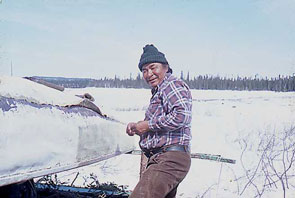 Puniss Nuke repairing his canoe at Ashtunekamiku. Photo courtesy Janet Kergoat.