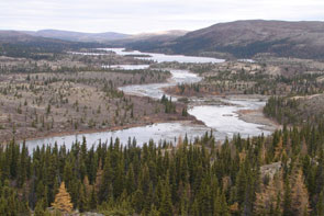 The view of the natuashu (steady) downstream along Kameshtashtan-shipu. The view is to the north towards the junction of Ashuapun-shipu and Emish-shipu. A traditional Innu travel route from Kameshtashtan left the river here, portage to the right of the photo, over to a brook draining into Nutakuanan-shipu. Photo courtesy Stephen Loring.
