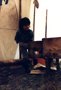 Innu boy stoking the fire at Kamashkushkatinau-nipi. Photo courtesy Camille Fouillard.